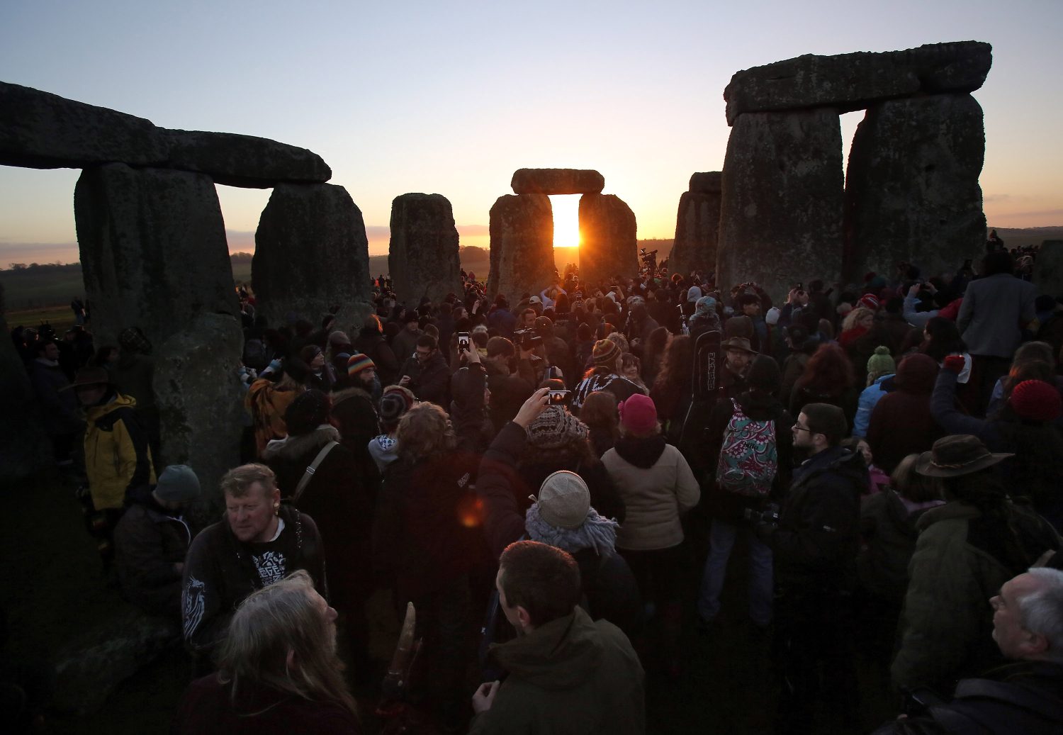Matt Cardy/Getty Images.AMESBURY, ENGLAND - DECEMBER 21: People gather to watch the sunrise as druids, pagans and revellers celebrate the winter solstice at Stonehenge on December 21, 2012 in Wiltshire, England. Predictions that the world will end today as it marks the end of a 5,125-year-long cycle in the ancient Maya calendar, encouraged a larger than normal crowd to gather at the famous historic stone circle to celebrate the sunrise closest to the Winter Solstice, the shortest day of the year.
